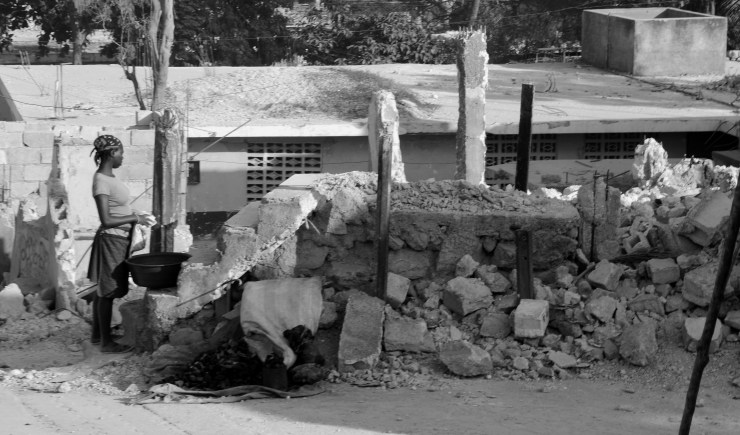 A woman stands next to a destoyed house in Port au Prince, Haiti. 