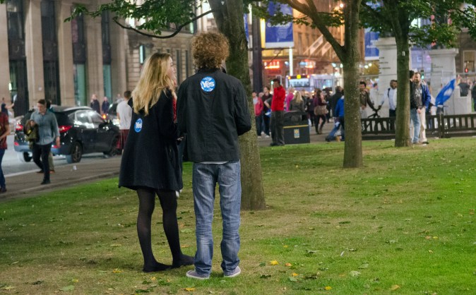 A couple quietly watch in George Square, Glasgow as the results of the referendum filter in. 